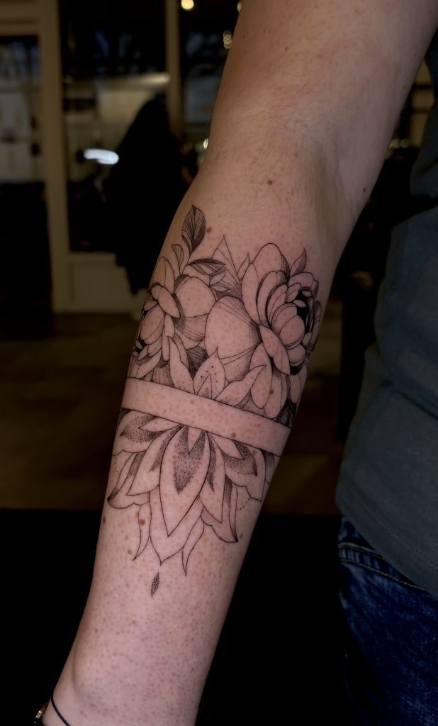 Brazalete floral con mandala tatuado alrededor del antebrazo